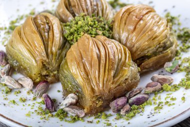Yeşil şam fıstığı tozu ve tereyağı kremalı Türk Midye Baklava 'sı (Midye Baklava). İslami Ziyafetler Kavramı.