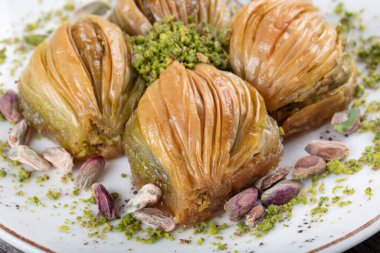 Yeşil şam fıstığı tozu ve tereyağı kremalı Türk Midye Baklava 'sı (Midye Baklava). İslami Ziyafetler Kavramı.