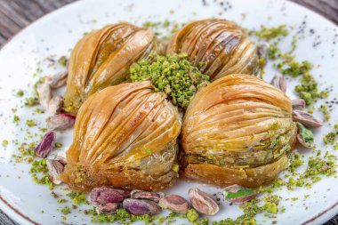 Yeşil şam fıstığı tozu ve tereyağı kremalı Türk Midye Baklava 'sı (Midye Baklava). İslami Ziyafetler Kavramı.