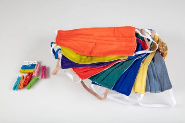 Üç tane elastik kulak halkalı yüz maskesi, üst üste yığılmış beyaz maske, arka planda mavi ve siyah. Coronavirus covid-19 salgını sırasında yeniden kullanılabilir pamuk kumaş maskeleri çok talep görüyor..