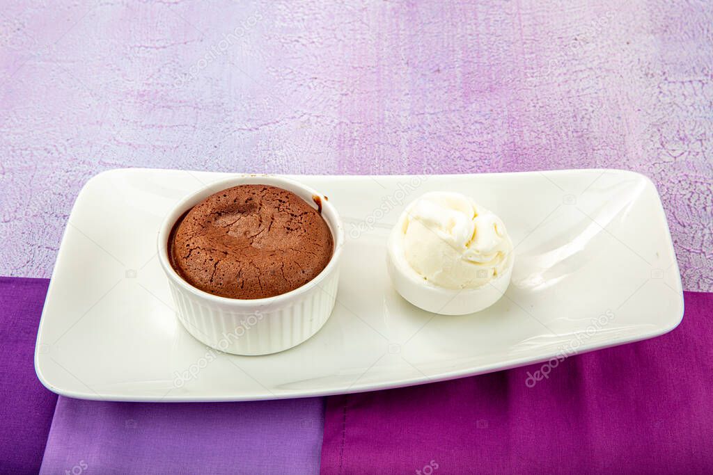 Delicious chocolate souffle with ice cream. Fluid chocolate souffle on white plate.