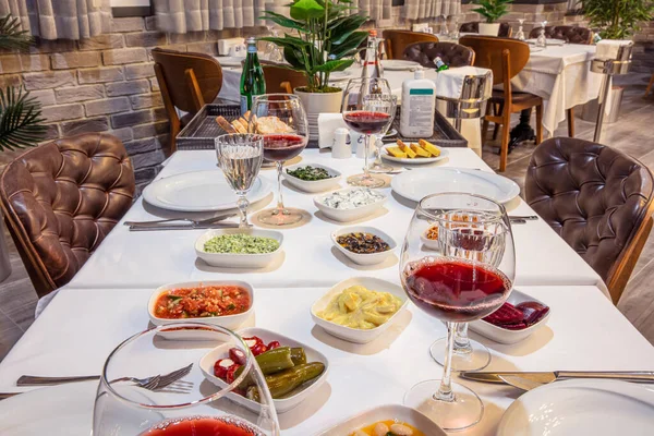 Appetizers on the table. Dining table with wine glass in front of fireplace, food and drink concept.