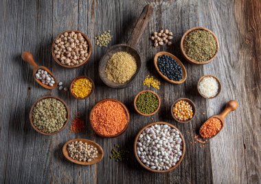 Vegan protein source.Various assortment of legumes, lentils, chickpea and beans assortment in different bowls on wooden table. Top view.