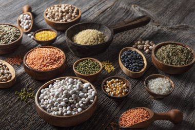 Vegan protein source.Various assortment of legumes, lentils, chickpea and beans assortment in different bowls on wooden table. Top view.