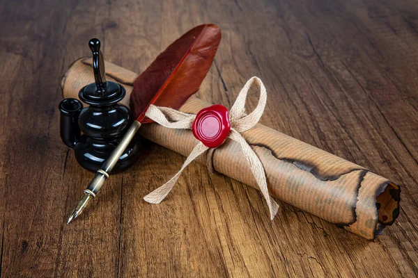 Photograph of a fountain pen with an old inkwell and several differently shaped nibs on papyrus with examples of calligraphy.