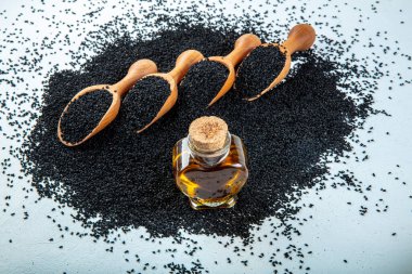 Siyah kimyon tohumları, doğal antioksidan. Kara kimyon tohumları ahşap kaşıkla ya da tahta arka planda kürekle gerekli yağ. Birçok hastalık için organik bitkisel ilaç.