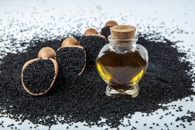 Siyah kimyon tohumları, doğal antioksidan. Kara kimyon tohumları ahşap kaşıkla ya da tahta arka planda kürekle gerekli yağ. Birçok hastalık için organik bitkisel ilaç.