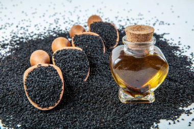 Siyah kimyon tohumları, doğal antioksidan. Kara kimyon tohumları ahşap kaşıkla ya da tahta arka planda kürekle gerekli yağ. Birçok hastalık için organik bitkisel ilaç.