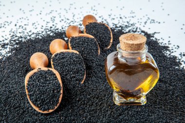 Siyah kimyon tohumları, doğal antioksidan. Kara kimyon tohumları ahşap kaşıkla ya da tahta arka planda kürekle gerekli yağ. Birçok hastalık için organik bitkisel ilaç.