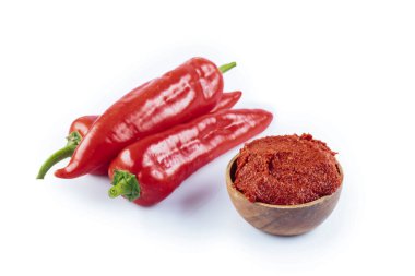 Türk usulü biber ezmesi (biber salcasi). Kırmızı soslu ahşap kase ve beyaz üzerine izole edilmiş taze kırmızı biber..