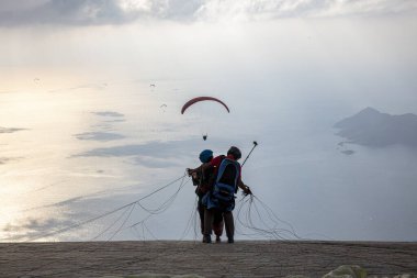 FethiyeOludeniz Babada dünyanın en önemli yamaç paraşütü bölgelerinden biri olarak kabul edilir. Mula, Türkiye. Cesur paraşütçüler Oludeniz tatil köyü yakınlarındaki Babadag dağından havalandılar.. 