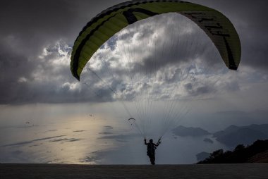 FethiyeOludeniz Babada dünyanın en önemli yamaç paraşütü bölgelerinden biri olarak kabul edilir. Mula, Türkiye. Cesur paraşütçüler Oludeniz tatil köyü yakınlarındaki Babadag dağından havalandılar.. 