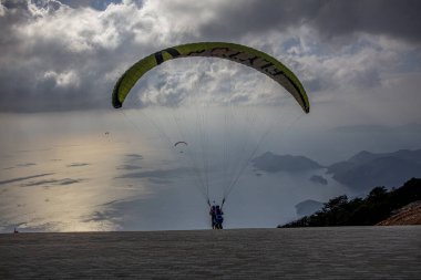 FethiyeOludeniz Babada dünyanın en önemli yamaç paraşütü bölgelerinden biri olarak kabul edilir. Mula, Türkiye. Cesur paraşütçüler Oludeniz tatil köyü yakınlarındaki Babadag dağından havalandılar.. 