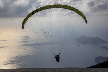 FethiyeOludeniz Babada dünyanın en önemli yamaç paraşütü bölgelerinden biri olarak kabul edilir. Mula, Türkiye. Cesur paraşütçüler Oludeniz tatil köyü yakınlarındaki Babadag dağından havalandılar.. 