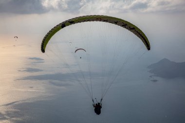 FethiyeOludeniz Babada dünyanın en önemli yamaç paraşütü bölgelerinden biri olarak kabul edilir. Mula, Türkiye. Cesur paraşütçüler Oludeniz tatil köyü yakınlarındaki Babadag dağından havalandılar.. 