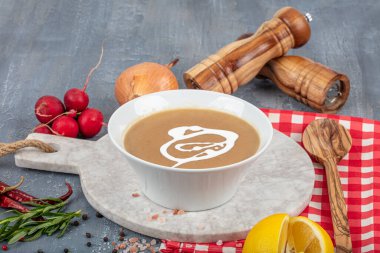 Fransız Soğan Çorbası, arka planda malzemelerle seramik bir kasede..