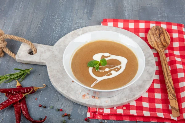 French Onion Soup in a ceramic bowl with ingredients in the background. Onion soup with croutones and creamed cheese.