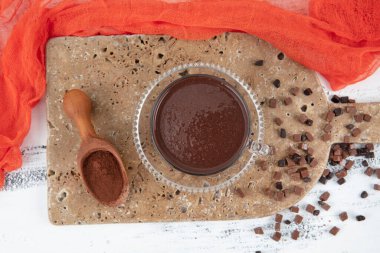 Bir fincan sıcak çikolata ve bir parça çikolata. Tahta masada bir fincan sıcak çikolata..