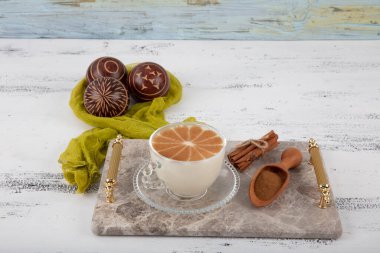 Tarçın tozu, sağlıklı baharat ve sonbahar kış mevsimi eskimiş beyaz ahşap masa üzerinde salep sütlü sıcak Türkiye içeceği.. 