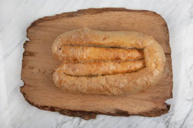 Türk usulü doldurulmuş filo hamuru borek Kol Boregi servis ediyordu. Peynir ve kıymalı turta mermer arka planda dilimlenir. Türkçe adı: Kol Boregi.