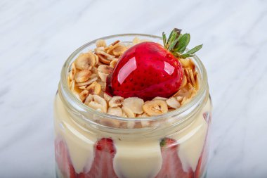 Çilekli manolya tatlısı. Bardak ağacı manolyasında. Açık mermer arka planda..