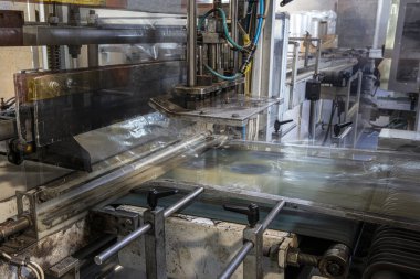 Koli bandı fabrikası. Koli bandı üretimi. Strapping Machine for Industrail Ambalaj Hattı, Fabrika, Endüstri ve Teknoloji konseptinde ambalaj hattı için modern makine.