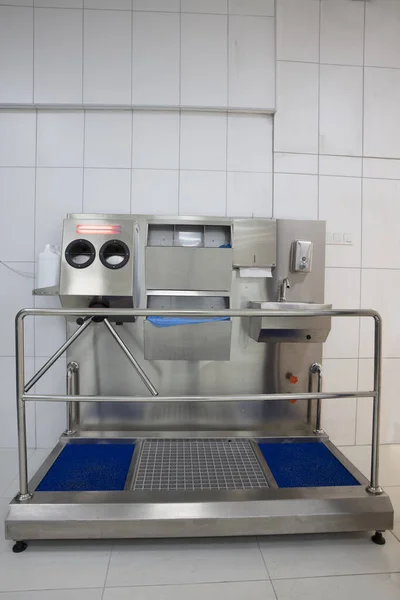 Hand hygiene station with turnstile gate and sanitizer before entering production area. Infection prevention, disinfection, industrial, covid 19, coronavirus concept