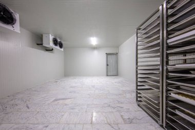 Depo dondurucusu, soğuk depo. Yiyecek deposu için soğutma odası. Dört vantilatörü olan boş bir sanayi odası buzdolabı..