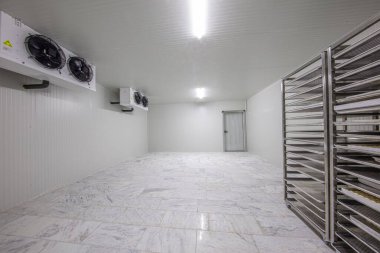 Depo dondurucusu, soğuk depo. Yiyecek deposu için soğutma odası. Dört vantilatörü olan boş bir sanayi odası buzdolabı..