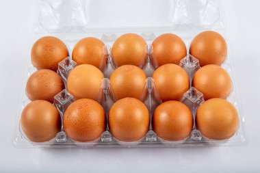 paketleme; kahverengi kutu; beyaz arkaplanda izole edilmiş bej yumurta; üst görünüm; 10 parça