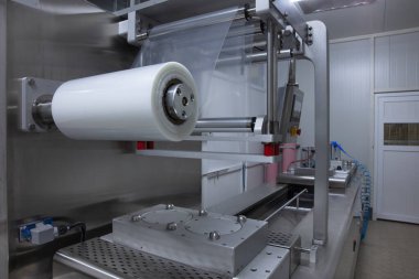 Yiyecek endüstrisi fabrikasındaki gıda vakum ambalaj makinesinde tereyağı ve peynir ambalajının işlenmesi. Yemek tereyağı ve peynir paketliyorum. Elektrik süpürgesi..