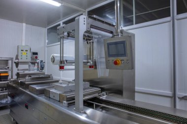 Yiyecek endüstrisi fabrikasındaki gıda vakum ambalaj makinesinde tereyağı ve peynir ambalajının işlenmesi. Yemek tereyağı ve peynir paketliyorum. Elektrik süpürgesi..