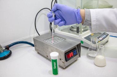 Hayvan sütünde inhibitör ve antibiyotik saptama sistemi. Süt antibiyotiği testi. Veteriner laboratuarda bir test yapıyor..