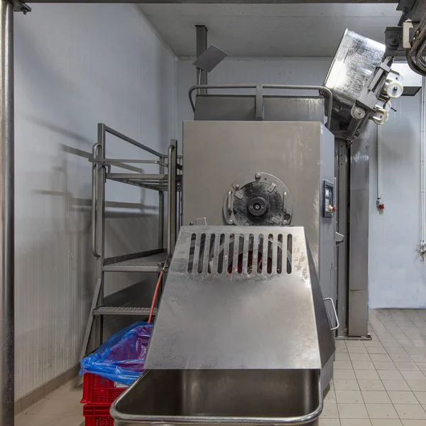 The meat in the Grinder. the meat industry. Minced meat being extruded from an industrial mincing machine.