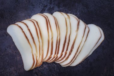 Beyaz, geleneksel at kuyruğu peyniri. Tütsülenmiş peynir. Tütsülenmiş peynir at kuyruğu ahşap arka planda izole edilmiş.. 