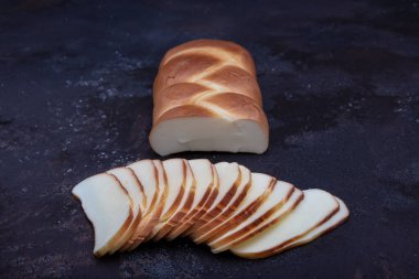 Beyaz, geleneksel at kuyruğu peyniri. Tütsülenmiş peynir. Tütsülenmiş peynir at kuyruğu ahşap arka planda izole edilmiş.. 