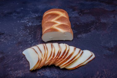 Beyaz, geleneksel at kuyruğu peyniri. Tütsülenmiş peynir. Tütsülenmiş peynir at kuyruğu ahşap arka planda izole edilmiş.. 