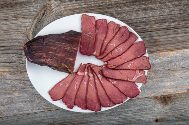 Tütsülenmiş et, ahşap rustik masalarda taze aromatik üzüm ve baharat eklenerek, geleneksel yöntemlerle üretilen organik tarım ürünleri..