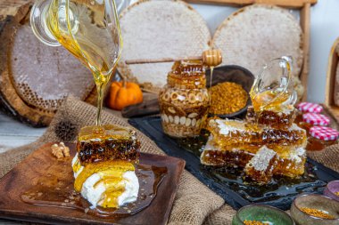 Kavanoza aromatik bal dök, yakından. Kavanozda bal, masada da ahşap ballı şeker..