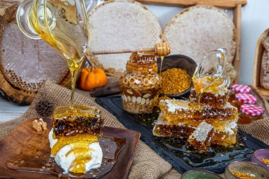 Kavanoza aromatik bal dök, yakından. Kavanozda bal, masada da ahşap ballı şeker..