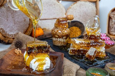 Kavanoza aromatik bal dök, yakından. Kavanozda bal, masada da ahşap ballı şeker..