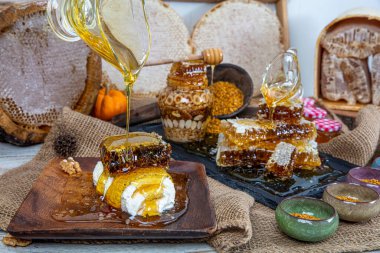 Kavanoza aromatik bal dök, yakından. Kavanozda bal, masada da ahşap ballı şeker..