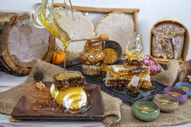 Kavanoza aromatik bal dök, yakından. Kavanozda bal, masada da ahşap ballı şeker..