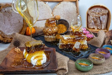 Kavanoza aromatik bal dök, yakından. Kavanozda bal, masada da ahşap ballı şeker..