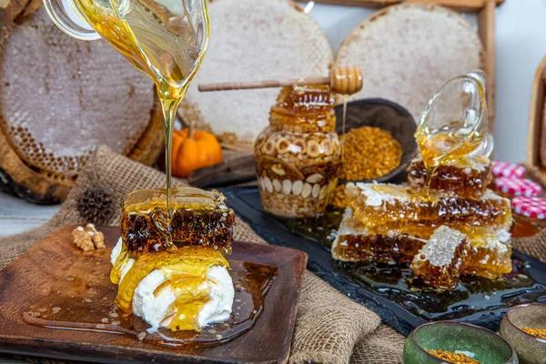 Kavanoza aromatik bal dök, yakından. Kavanozda bal, masada da ahşap ballı şeker..