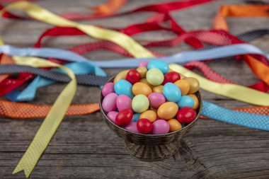 Renkli badem şekeri. İçinde badem olan küçük renkli yumurta şekilli şekerler. Tahta zemin üzerine şekerli badem. Kurban Bayramı (Ramazan Bayramı) kavramı.