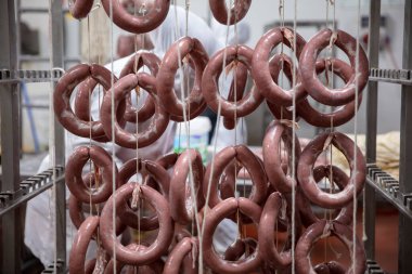 Et fabrikasındaki sosis sigara içmek için hazırlandı. Lezzet üretimi. Fabrika deposunda sosisler (Sucuk). Sosis üretim hattı. Sanayi sosis üretimi.