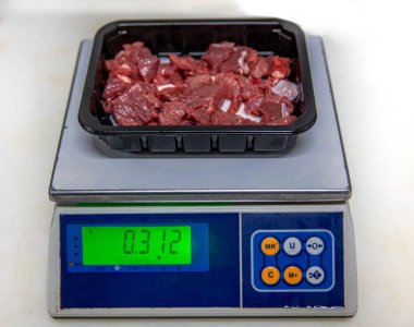 Metin için fotokopi alanı olan köpük bir kabın içinde taze kesilmiş kırmızı et (küp şeklinde doğranmış). Terazide doğranmış et..