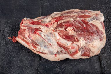 Kuzu omzu. Ahşap bir arka planda kuzu eti (fileto, sırt, omuz, göğüs eti ve boyun).