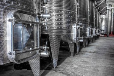 Şaraphanede şarap fermantasyonu için çelik şarap tankları. Mayalanma için büyük parlayan tankları olan modern şarap fabrikası..
